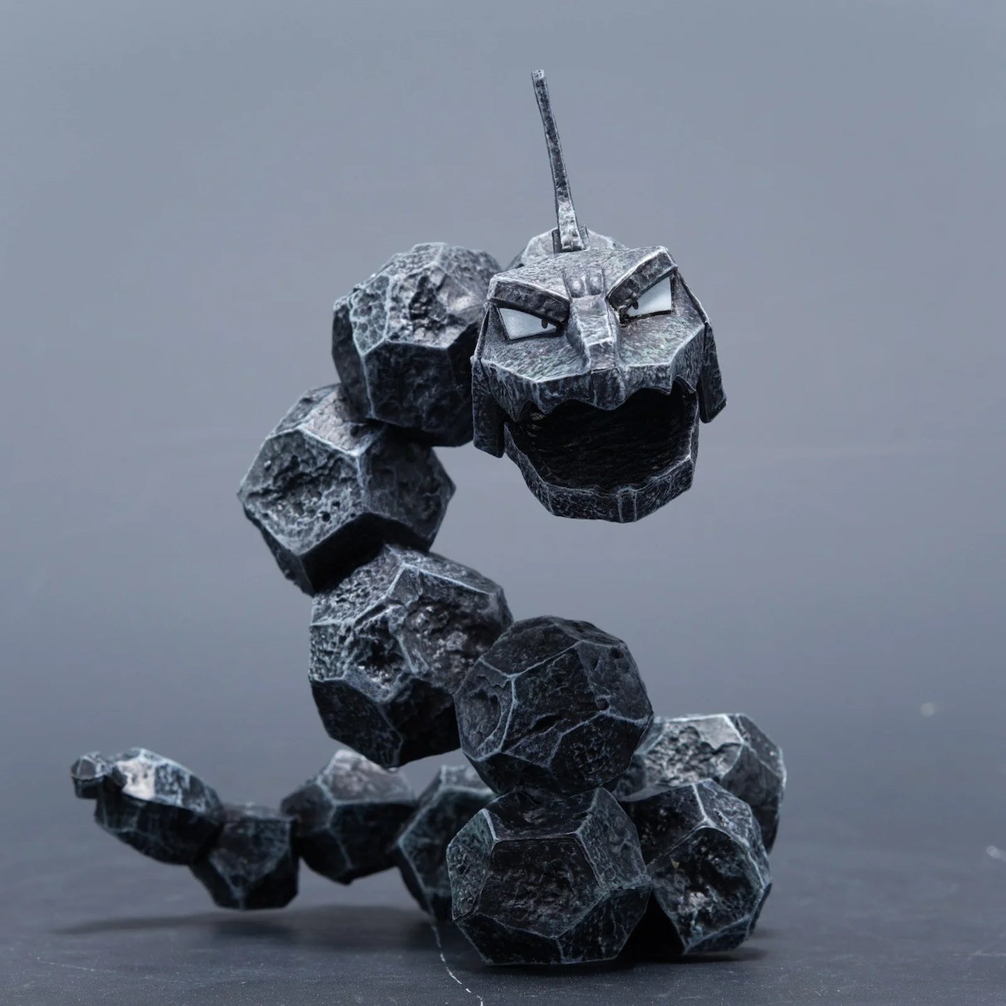 Onix-inspired rock serpent toothbrush holder figurine in black, desktop product photo