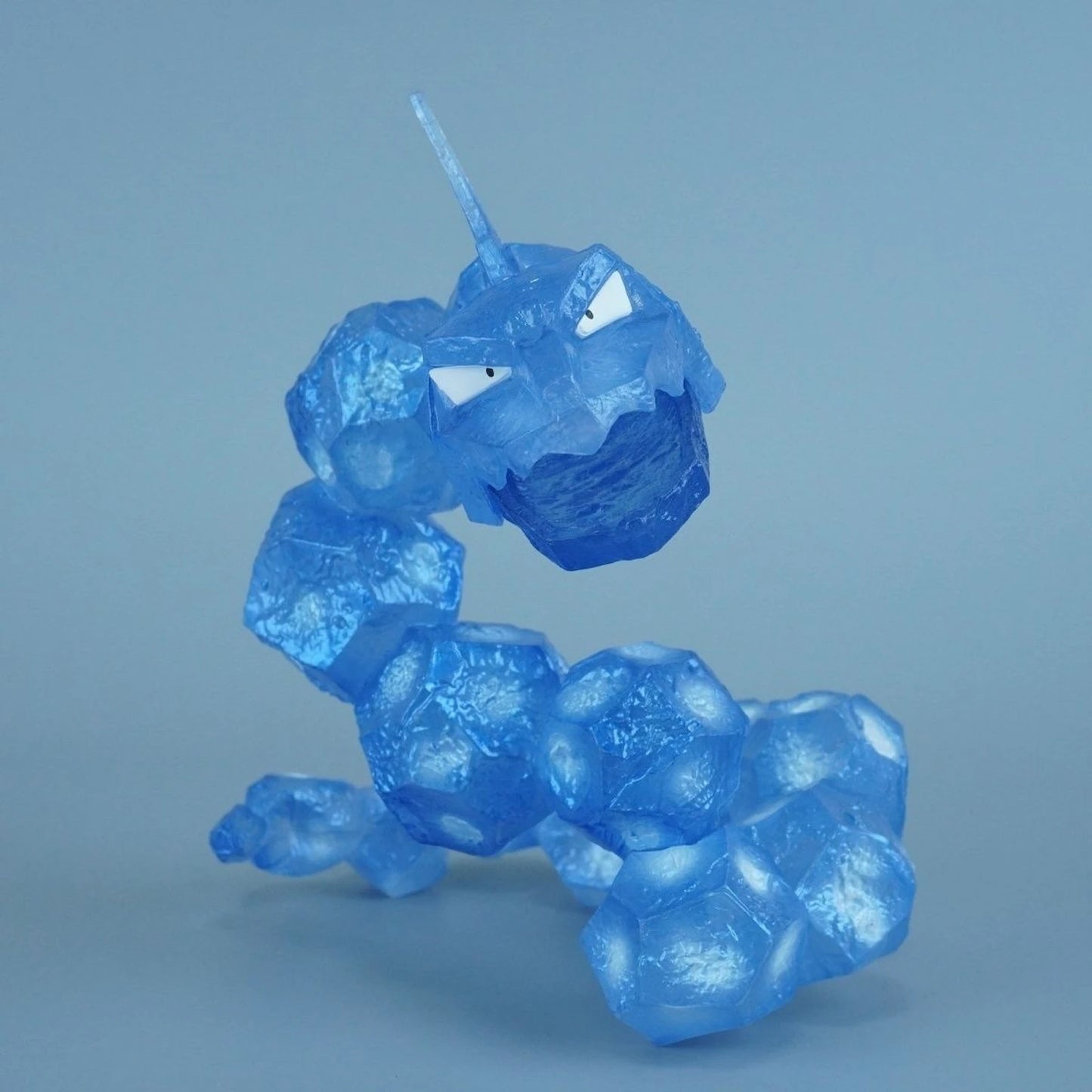 Translucent blue Onix-inspired rock serpent toothbrush holder figurine, close-up product photo