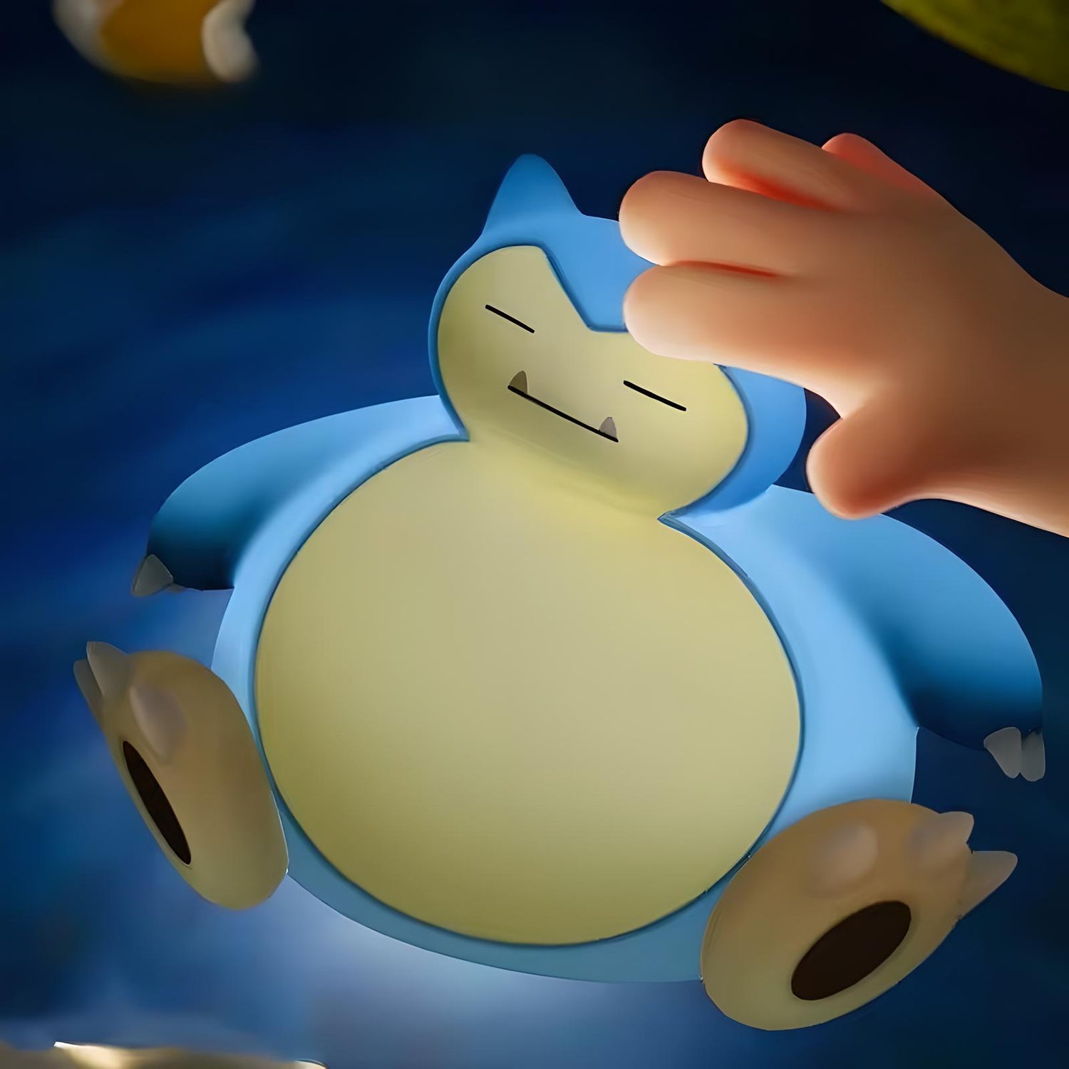 Hand tapping Snorlax-inspired silicone night light to adjust brightness, cozy warm glow in bedroom